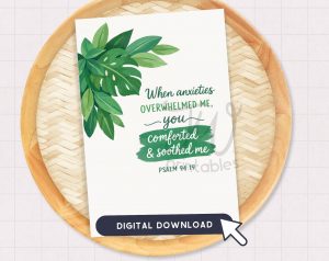 A white card with green leaf illustrations and the text "When anxieties OVERWHELMED ME, you comforted & soothed me PSALM 94:19" is displayed on a round wooden tray, with a "DIGITAL DOWNLOAD" button and a mouse cursor at the bottom.