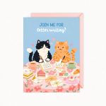 A greeting card features two cartoon cats, one black and white and one orange tabby, sitting at a floral table writing letters, surrounded by tea, cake, macarons, and other pastries, with the text "JOIN ME FOR letter writing?" at the top.